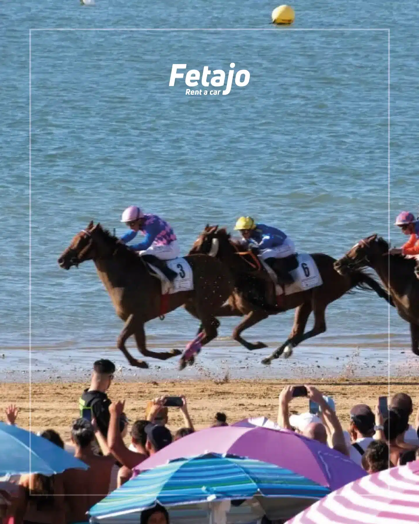 Jockeys racing thoroughbred horses along the beach at the Sanlúcar horse races with spectators watching from the shore