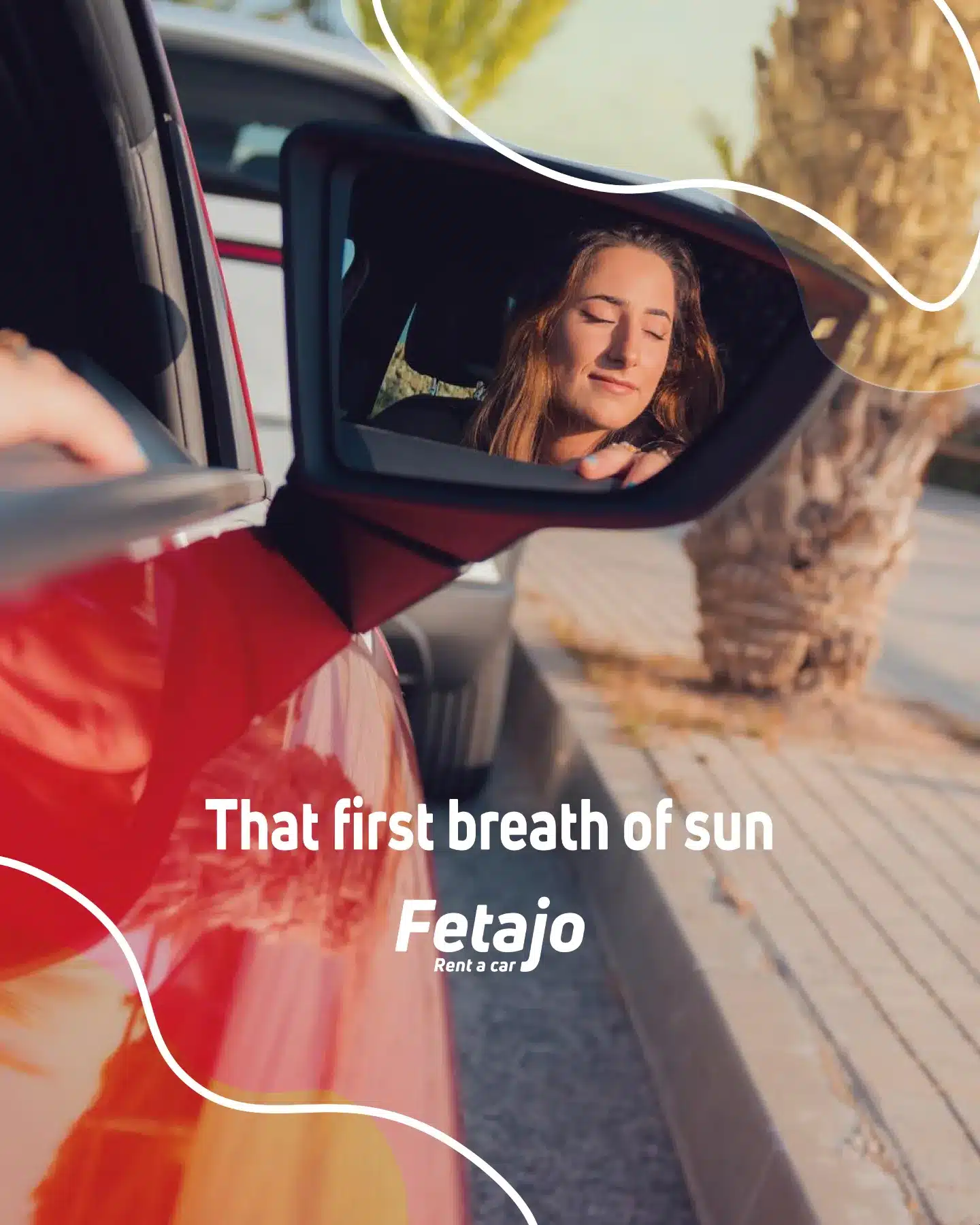 Woman leaning out of a red car with the sun on her face, car rental in Málaga with Fetajo Rent a Car