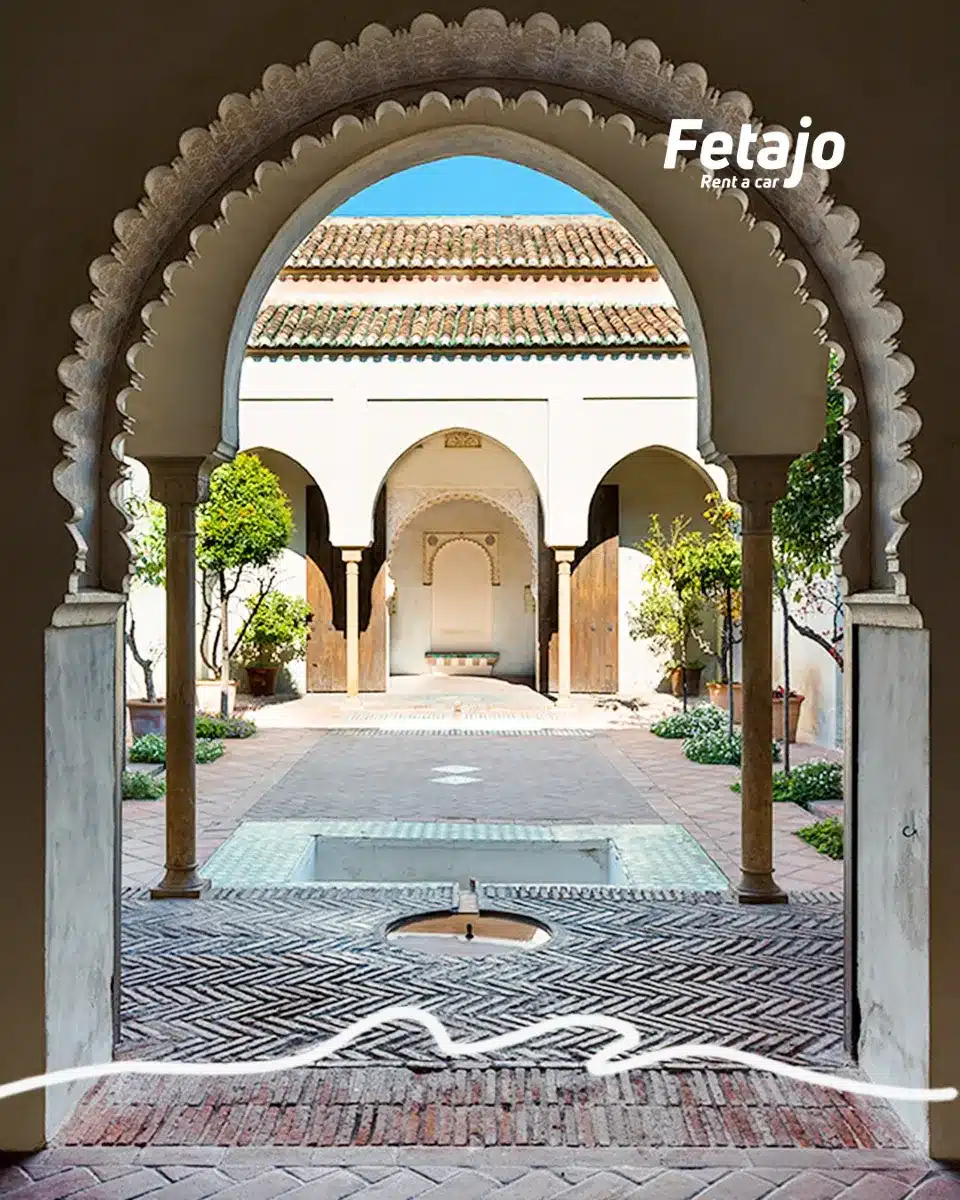 Horseshoe arch opening onto a Moorish courtyard with orange trees in Málaga